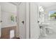 All-white bathroom featuring a pedestal sink, black and white floors, and wainscoting at 1401 E North St, Tampa, FL 33604