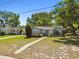 Charming single story home with lush landscaping, a sidewalk, and a well maintained lawn at 1401 E North St, Tampa, FL 33604