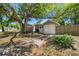 View of the detached garage with an attached room and a large shady tree with a fenced in yard at 1401 E North St, Tampa, FL 33604
