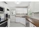 Well-lit kitchen featuring white cabinets, butcher block countertops and stainless steel appliances at 1401 E North St, Tampa, FL 33604