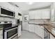 Cozy kitchen with white cabinets, stainless steel appliances, and wood countertops at 1401 E North St, Tampa, FL 33604