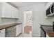 Kitchen featuring white cabinets, stainless steel appliances, and view to the dining room at 1401 E North St, Tampa, FL 33604
