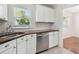 Kitchen with stainless steel dishwasher, white cabinets, and butcher block countertops at 1401 E North St, Tampa, FL 33604