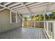 Covered porch with wood floors and a white railing overlooking backyard at 1401 E North St, Tampa, FL 33604