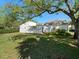 A modern home backyard featuring a green grass lawn and a large tree providing plenty of shade at 14215 Cypress Cir, Tampa, FL 33618