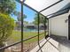 A screened outdoor patio with views of a well-kept lawn and fenced community swimming pool at 14215 Cypress Cir, Tampa, FL 33618