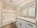 Bathroom featuring shower-tub combo, large mirror, and granite vanity at 17114 Carrington Park Dr # 207, Tampa, FL 33647