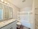 Bright bathroom featuring a vanity with granite countertop, and shower over tub, with white tile surround at 17114 Carrington Park Dr # 207, Tampa, FL 33647