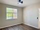 Clean bedroom with neutral paint, wood-look flooring, and a large window providing ample natural light at 17114 Carrington Park Dr # 207, Tampa, FL 33647