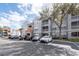 Exterior view of condo building with parking lot, landscaping, shade trees, and blue sky at 18001 Richmond Place Dr # 1032, Tampa, FL 33647