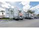 Exterior view of condo building with parking lot, landscaping, and blue sky at 18001 Richmond Place Dr # 1032, Tampa, FL 33647