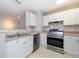 Kitchen with white cabinetry, stainless steel appliances, and ample countertop space at 18001 Richmond Place Dr # 1032, Tampa, FL 33647