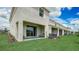 Townhome backyard featuring a covered patio, green grass, and a row of similar units at 218 Royal Spoonbill Dr, Ruskin, FL 33570