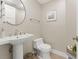 Half bath with pedestal sink, neutral wallpaper and decorative accents at 2410 Harbourside Dr # 142, Longboat Key, FL 34228