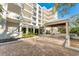 Luxury condo building with multiple balconies, covered entrance, and meticulously maintained grounds at 2410 Harbourside Dr # 142, Longboat Key, FL 34228