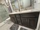 Bathroom featuring double sinks with granite counters and a glass-enclosed shower at 2465 Northside Dr # 604, Clearwater, FL 33761