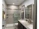 Updated bathroom featuring a double sink vanity, granite countertops, and a glass-enclosed shower at 2465 Northside Dr # 604, Clearwater, FL 33761