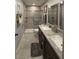 Updated bathroom featuring a double sink vanity, granite countertops, and a glass-enclosed shower at 2465 Northside Dr # 604, Clearwater, FL 33761