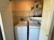 A compact laundry area features a washer, dryer, wire shelving, and water heater at 2465 Northside Dr # 604, Clearwater, FL 33761