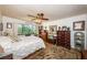 Comfortable bedroom showcasing a large window, ceiling fan, wood floors, and multiple dressers at 2537 Royal Pines Cir # 19I, Clearwater, FL 33763