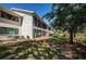The backyard of the property has lush green grass, trees, and a glimpse of the building's exterior at 2537 Royal Pines Cir # 19I, Clearwater, FL 33763