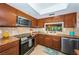 Functional kitchen area with stainless steel appliances and a pass-through window at 2537 Royal Pines Cir # 19I, Clearwater, FL 33763