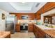 Well-lit kitchen with stainless steel appliances, wood cabinets, and earth-tone backsplash at 2537 Royal Pines Cir # 19I, Clearwater, FL 33763