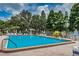 Outdoor pool area surrounded by lounge chairs and mature trees, perfect for relaxation and recreation at 2537 Royal Pines Cir # 19I, Clearwater, FL 33763