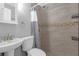 Bathroom featuring a tiled shower, pedestal sink, and built-in shelving at 27103 Frampton Ave Ave, Brooksville, FL 34602