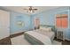 Bright bedroom with blue walls, two windows, carpet, and a ceiling fan at 28935 Lucero Ln, Wesley Chapel, FL 33543