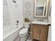 Bright bathroom featuring a tub-shower combo, decorative wall art and a stylish vanity with a marble countertop at 2927 Northfield Dr, Tarpon Springs, FL 34688