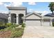 Beautiful stucco home featuring arched entryways, lush landscaping and a convenient three-car garage at 2927 Northfield Dr, Tarpon Springs, FL 34688