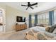 Bright primary bedroom featuring large windows, window treatments, hardwood furniture, and a ceiling fan at 2927 Northfield Dr, Tarpon Springs, FL 34688