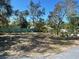 Spacious backyard with a green fence and scattered chairs and potted plants at 300 S Highland Ave, Tarpon Springs, FL 34689