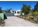 A view of the concrete driveway leading to the home, enhanced by bordering landscaping at 300 S Highland Ave, Tarpon Springs, FL 34689