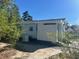 Back exterior view of cozy cottage with neutral color and landscaped yard at 300 S Highland Ave, Tarpon Springs, FL 34689