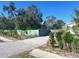 View of the property and driveway with a wooden privacy fence and landscaping at 300 S Highland Ave, Tarpon Springs, FL 34689