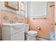 Charming bathroom with pink tile, a white toilet and sink, and decorative green trim at 3124 9Th N Ave, St Petersburg, FL 33713