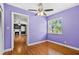 Bedroom with light purple walls, hardwood floors, a ceiling fan, and a view into the living room at 3124 9Th N Ave, St Petersburg, FL 33713