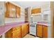 Cozy kitchen with wooden cabinets, pink countertops, and white appliances at 3124 9Th N Ave, St Petersburg, FL 33713