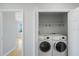 Bright laundry room showcasing modern washer and dryer with overhead storage at 345 Bayshore Blvd # 1502, Tampa, FL 33606