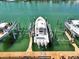 Overhead view of a boat lift with a triple-outboard motor boat docked between two other boats at 350 Pinellas Bayway S # 2, St Petersburg, FL 33715