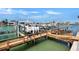 Boat lift with a motorboat on a private dock with a walkway under a sunny, blue sky at 350 Pinellas Bayway S # 2, St Petersburg, FL 33715