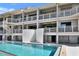 Exterior view of a condo complex boasting a refreshing pool and multiple floors with private balconies at 350 Pinellas Bayway S # 2, St Petersburg, FL 33715