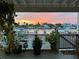 Picturesque view of the waterfront and boats at sunset from a covered outdoor porch with lush plants at 350 Pinellas Bayway S # 2, St Petersburg, FL 33715