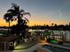 Inviting waterfront home boasts a private dock with boat lift and an outdoor lounge area with colorful sunset sky at 350 Pinellas Bayway S # 2, St Petersburg, FL 33715