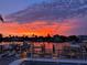 Waterfront view featuring a vibrant sunset, palm trees, private docks, and tranquil waters at 350 Pinellas Bayway S # 2, St Petersburg, FL 33715