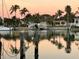 Serene waterfront view with the reflections of palm trees and houses mirroring on the calm water surface at 350 Pinellas Bayway S # 2, St Petersburg, FL 33715