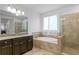 Elegant bathroom featuring a separate tub and glass-enclosed shower and beautiful dark wood cabinets at 3615 W Kensington Ave, Tampa, FL 33629