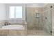 Elegant bathroom with a separate tub and glass-enclosed shower with tiled surround and built-in niche at 3615 W Kensington Ave, Tampa, FL 33629